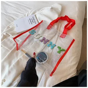 Transparente PVC Strandtasche mit bunten Buchstaben, rotem Rand und großem Fassungsvermögen.