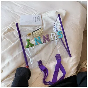 Transparente PVC Strandtasche mit bunten Buchstaben und lila Besatz, stilvolle Sommertasche für Damen.