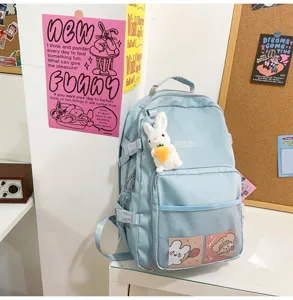 Zaino per studenti azzurro chiaro con grazioso ciondolo a coniglio e tasche a rete pratiche.