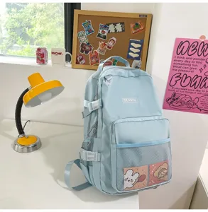 Zaino casual azzurro in stile giapponese con tasca frontale in rete e fibbie per studenti.