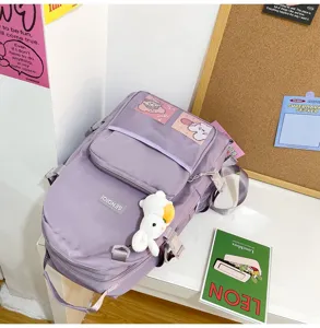 Zaino per studenti monocolore minimalista casual con ciondolo in peluche e tasca a rete.