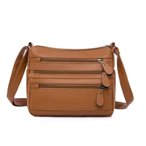 Bolso bandolera clásico de cuero suave marrón con múltiples bolsillos para mujeres.