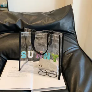 Transparente PVC Strand-Tasche mit schwarzem Rand und bunten Glitzer SUNNY Buchstaben.