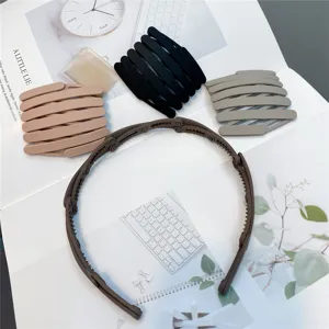 Foldable teeth hair band detail shot, portable plastic black brown gray headwear for use.