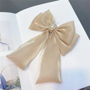 Champagne organza bow hair clip detail, elegant pearl diamond center with long ribbons.