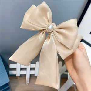 Champagne organza bow hair clip with pearl rhinestone center, elegant long ribbon design for women.