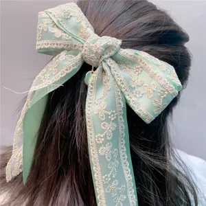 Exquisite mint green double-layer lace bow hair clip with delicate embroidery and pearl detail.