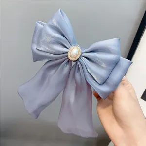 Light blue multi-layer bow hair clip with elegant pearl rhinestone center and long streamers.