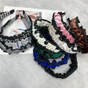 Detailed close-up shot of colorful velvet and houndstooth ruffled headbands for women.