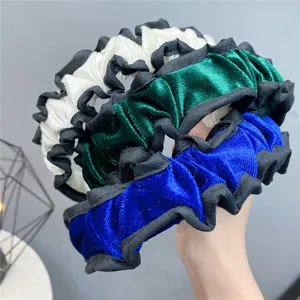 Detailed view of the stylish velvet ruffled headband featuring vibrant color-blocked designs.