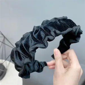 Black velvet ruffled headband detail showing soft plush texture and elegant pleated design.