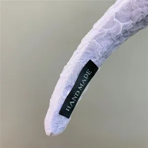 Detail shot of purple bubble gauze headband, soft sponge padding, handmade fabric tag texture.