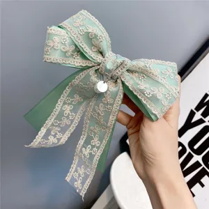 Green lace bow hair clip featuring sweet pearl pendant, elegant hair accessory for women.