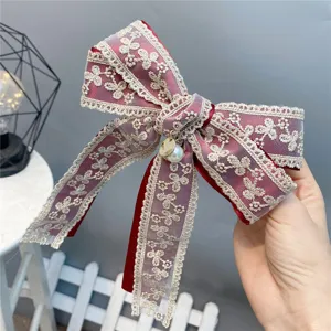 Detailed close-up view of a sweet red lace bow hair clip featuring a pearl pendant.