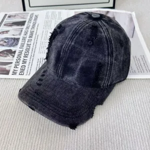 Gros plan sur la casquette de baseball vintage délavée et déchirée en tissu noir texturé.