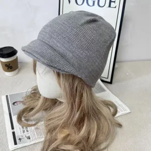 Detalle en primer plano de un gorro de punto gris con doble ala para el invierno.
