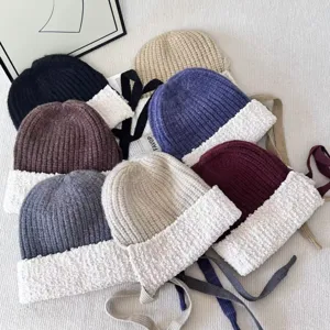 Detailed shot of winter knitted beanies with plush brims and cute ties in multiple colors.