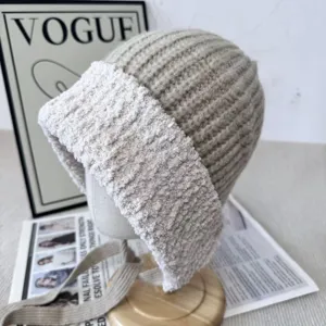 Detail shot of winter knitted plush spliced beanie hat with earflaps and cute ribbon ties.