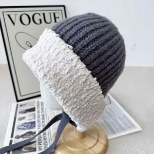 Cozy winter knit hat with plush brim and earflaps, stylish grey woolen beanie for women.