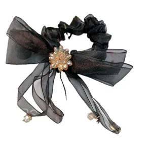 Zwarte organza haarscrunchie met sprankelende champagne kristalbloem en lange linten.