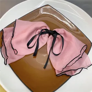 Oversized pink chiffon hair bow clip with black edge and ribbon, sweet fairy girl hair accessory for women.