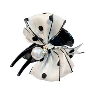 Elegant polka dot hair claw clip featuring a pearl charm and bow detail. Perfect accessory.