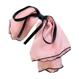 Extra-large pink chiffon bow hair clip detail showing black ruffle edge and ribbon ties.