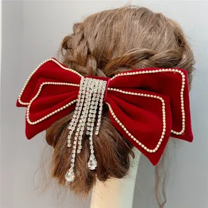 Red velvet bow hair clip with sparkling rhinestone fringe and crystal drop pendants. Detail.