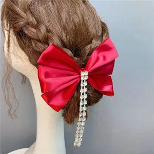 Red satin bow hair clip with rhinestone tassel, perfect for wedding and party hair styling.