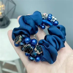 Blue satin hair scrunchie with elegant pearls and sparkling black flower charms, elastic.
