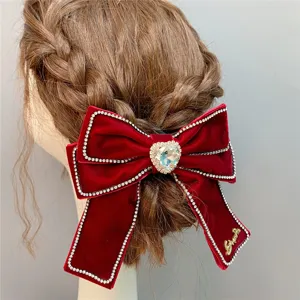 Red velvet bow hair clip with sparkling rhinestones and center heart crystal for elegant hairstyles.