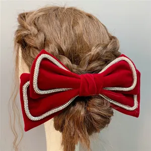 Red velvet bow hair clip with rhinestone trim, elegant bridal wedding headwear accessory.