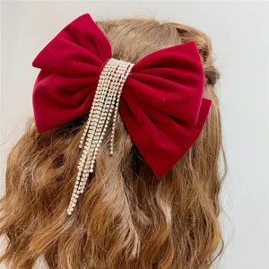 Elegant red velvet hair bow with sparkling rhinestone tassels for weddings and parties.