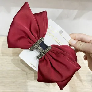 Elegant red velvet hair bow with sparkling rhinestone H buckle, perfect for weddings and parties.