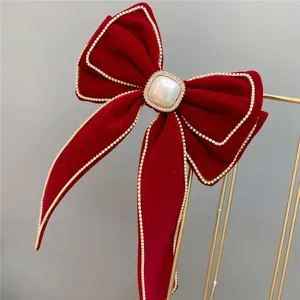 Red velvet bow hair clip with rhinestones and pearl center for wedding bridal hair accessories.