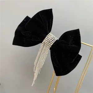 Black velvet bow hair clip with sparkling rhinestone fringe detail, elegant hair accessory.