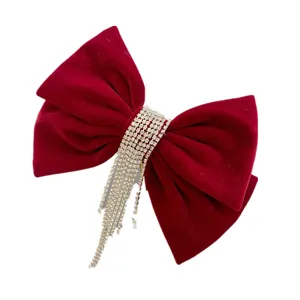 Red velvet bow hair clip detail with sparkling rhinestone tassels for wedding and bridal wear.