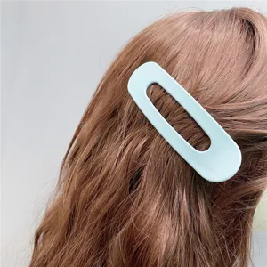 Detail shot of a light blue hollow acrylic hair clip, elegant geometric design for styling.