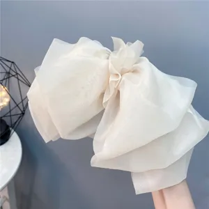 Detail shot of a large multi-layered organza bow hair clip with spring clip fastening.