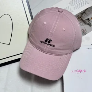 Pink washed cotton baseball cap for women with black embroidered letters, casual sun hat.