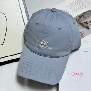Classic washed cotton baseball cap with embroidered letter design for casual outdoor wear.