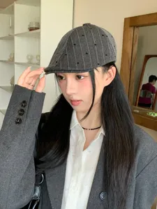 Detailed view of the Japanese retro style grey striped newsboy cap with cute heart embroidery.