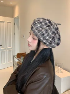 Gros plan du béret écossais à carreaux style rétro vintage en tissu doux et élégant.