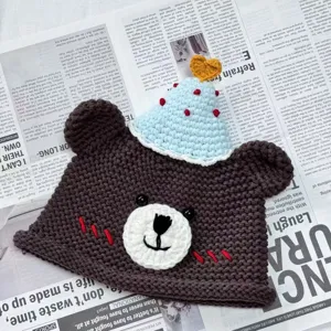 Handmade crochet cute bear hat detail shot, soft wool knit winter accessory gift.