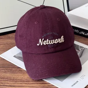 Retro embroidered baseball cap detail, vintage burgundy cotton hat with stylish front lettering.