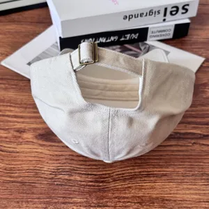 Detail view of the vintage beige baseball cap showing the adjustable metal buckle closure.