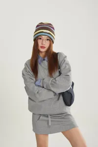 Detailed view of the stylish colorful striped knit beanie with small logo patch, fashion winter hat.