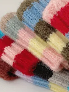 Colorful striped knit beanie fabric detail shot, cozy autumn winter apparel texture.