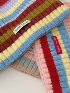 Detailed view of colorful striped knit beanie winter warm cozy fashionable hat for women daily wear.