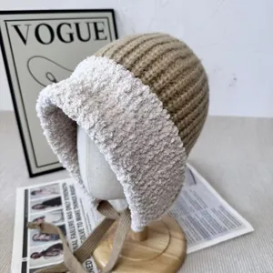 Knitted plush spliced earflap hat detail view showing warm winter design and cute ties.